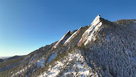 Sunrise-over-flatirons-mountain-landscape-in-Boulder,-Colorado-on-a-sunny-winter-day-covered-in-snow