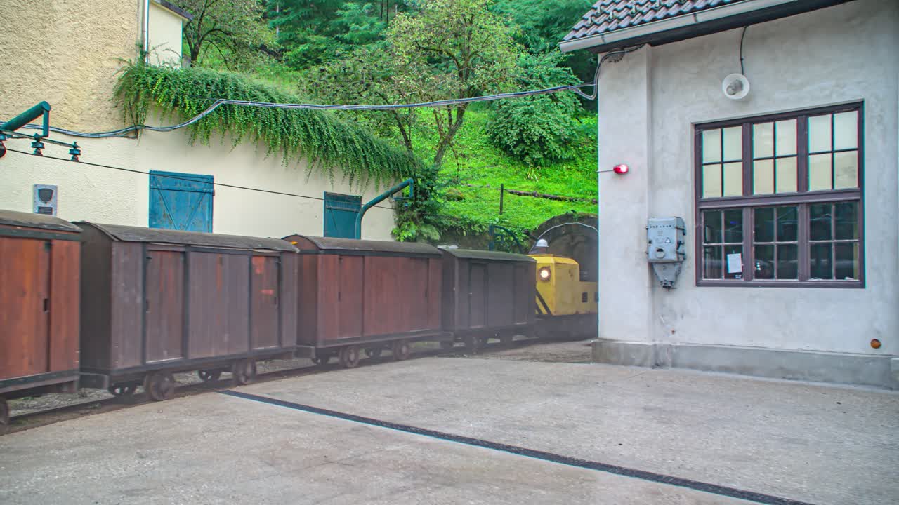 Yellow locomotive and wagons enter in Peca mine. Slovenia