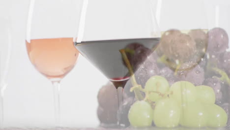 compuesto de copas con copas de vino blanco, rosado y rojo sobre uvas sobre fondo blanco