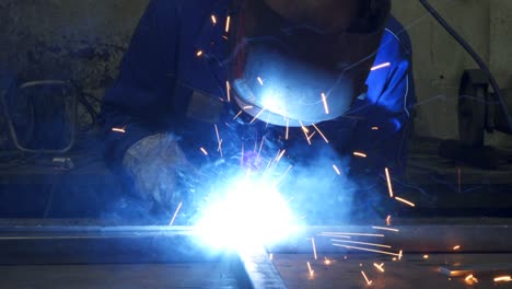 obrero anónimo soldando construcción metálica en el taller