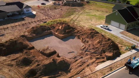 a drone shot spinning around a recently dug hole for the starting of a new house about to built