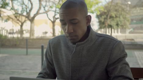 uncertain young freelancer working with laptop