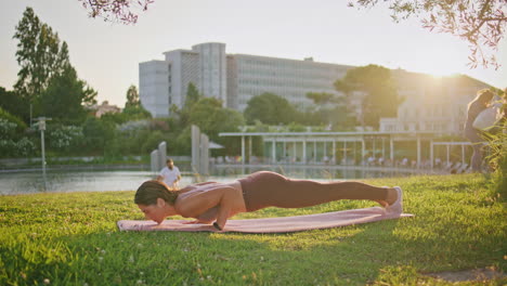 posición de tabla de atleta activo en la naturaleza de los rayos de sol. mujer estirando la postura de cobra