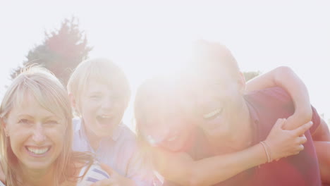 family of four smiling to camera in the garden, close up