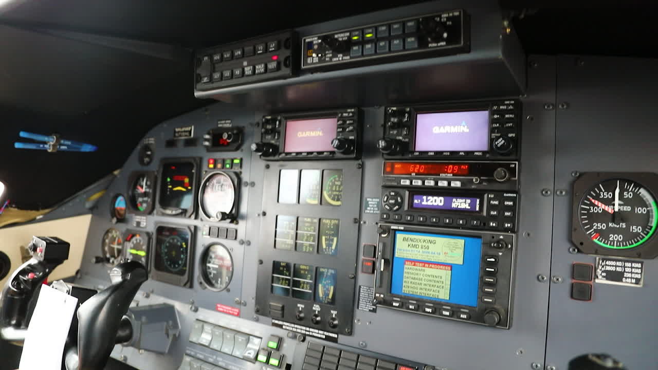 A man adjusts the instrument panel in the cockpit of a Pilatus PC-12 airplane.