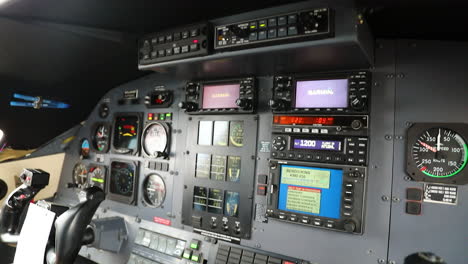 a man adjusts the instrument panel in the cockpit of a pilatus pc-12 airplane.