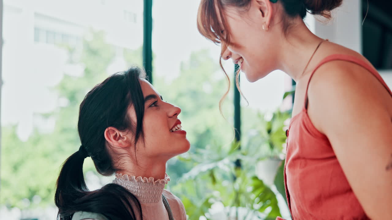 두 여자 가 장난스럽게 코 를 만지고 있다