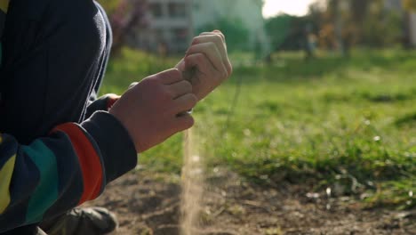 cerca de 120 fps cámara lenta de un niño caucásico jugando con tierra en un campo, en un día soleado