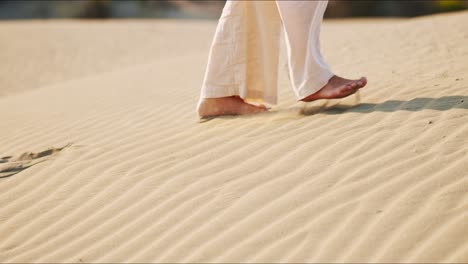 Close-up-of-young-brunette-yoga-instructor-walking-barefoot-in-the-sand