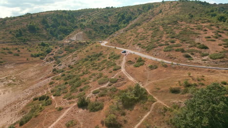 camino a través de las montañas con vegetación verde y tierra árida en italia - toma aérea de drones