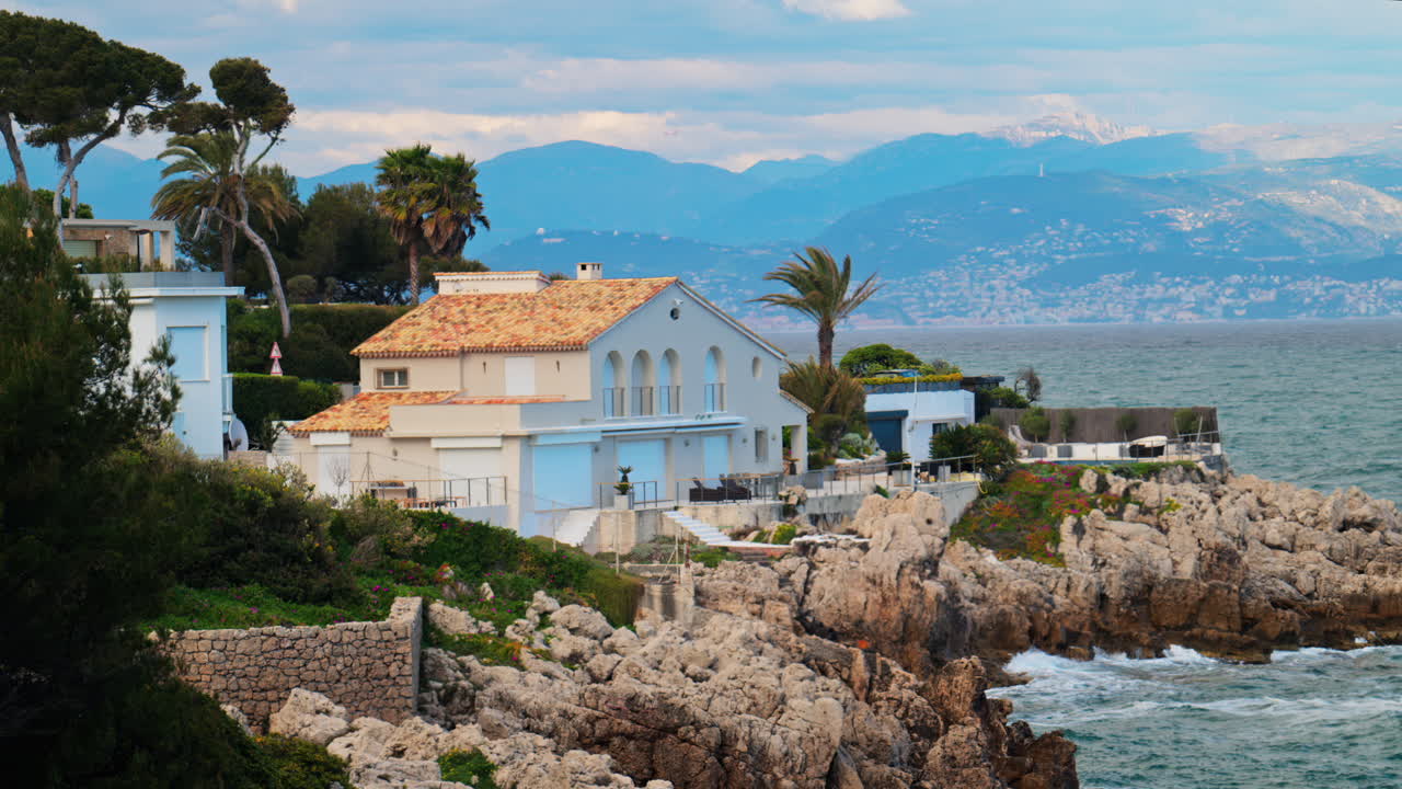 View of a villa on the coast with the waves of the sea crashing on the rocks