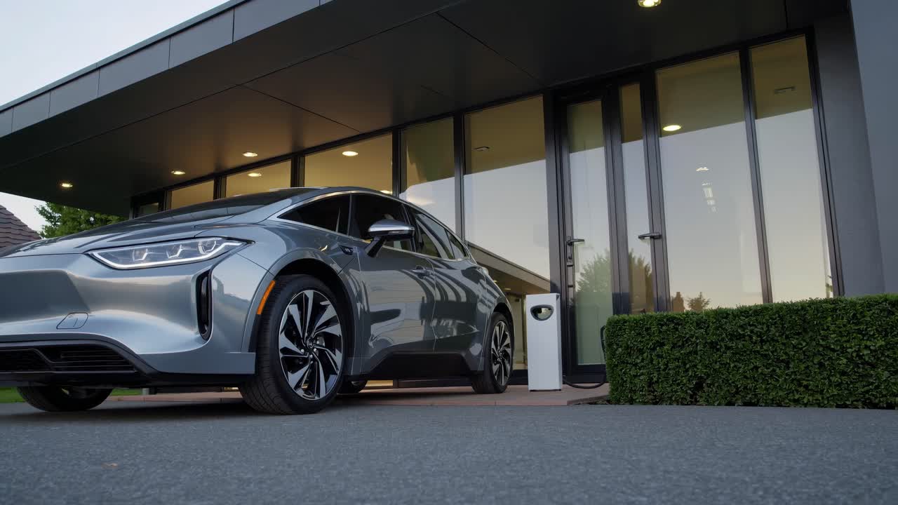 Low-angle video shot of a sleek electric car charging at a modern home, highlighting eco-friendly