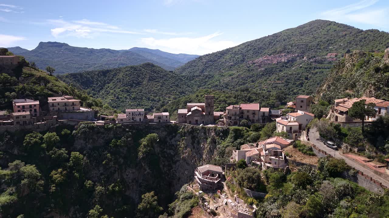 Vista aerea del Castello di Pentefur a Savoca, Sicilia, con lussureggianti colline verdi.