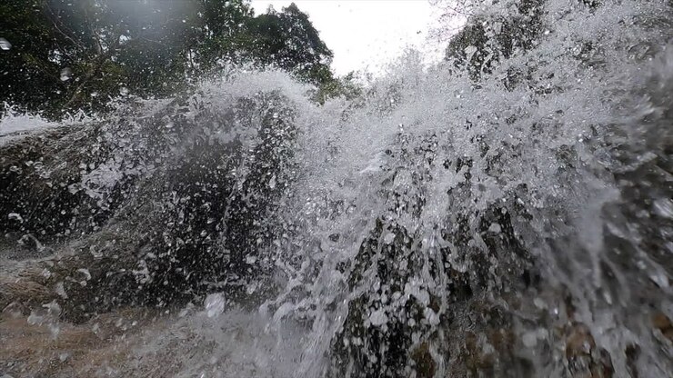 Immerso in una suggestiva cascata nel parco nazionale di Erawan, Thailandia.