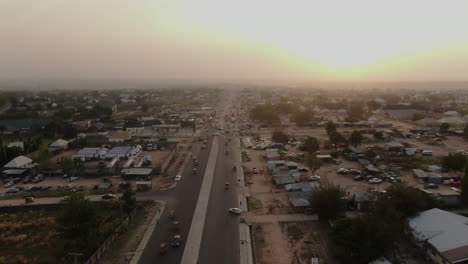 Highway-through-Jalingo-Town,-Nigeria-on-a-hazy,-smoggy-day---aerial-flyover