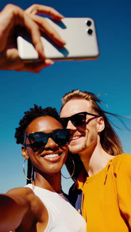 happy couple or friends taking a selfie together outdoors