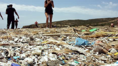 contaminación ambiental con basura plástica en la playa y la gente la ignora