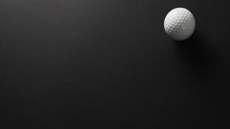 Close-up-of-golf-ball-on-black-background,-copy-space,-slow-motion