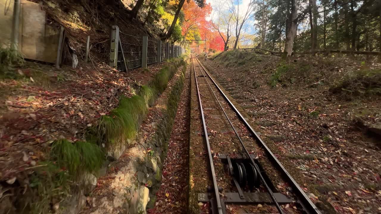 Cable car riding down fall color mountain, backside POV shot