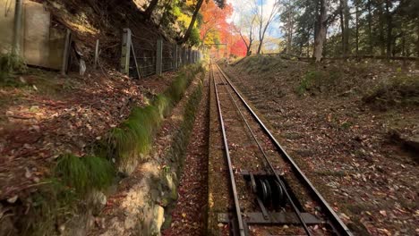 cable car riding down fall color mountain, backside pov shot