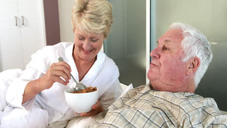 senior woman feeding her husband