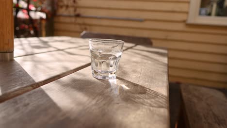 un vaso de agua en una mesa de madera