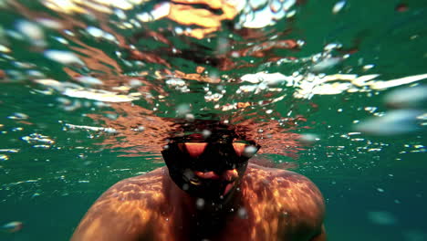 un hombre con una máscara de snorkel en la superficie del mar en dahab, egipto