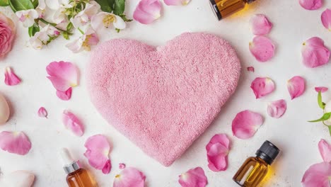 pink heart-shaped pillow with rose petals and essential oils