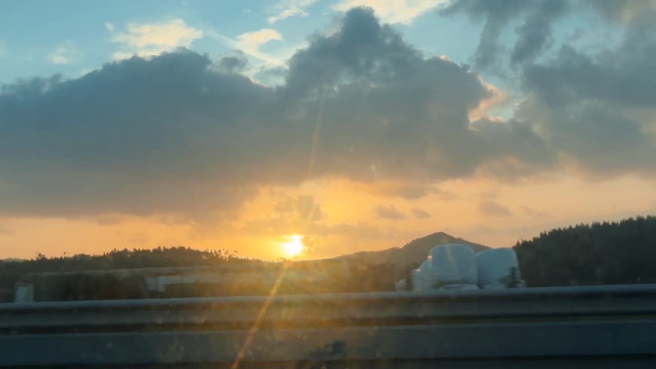 走行中の車の窓から見える美しい夕焼けの景色