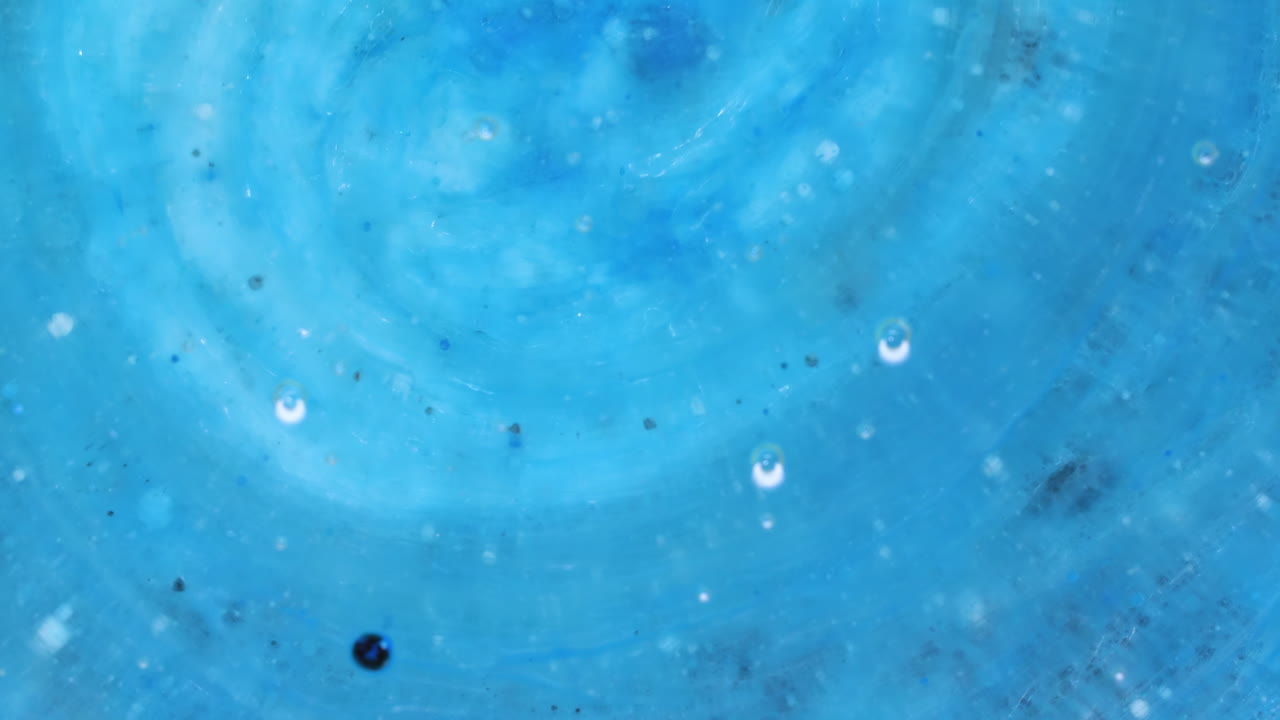 추상적인 예술 배경은 회전하는 은, 파란색과 검은색, 잉크 거품이 터지고 반응합니다.