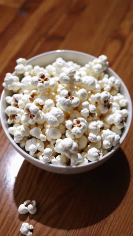 popcorn in a white bowl on a wooden table