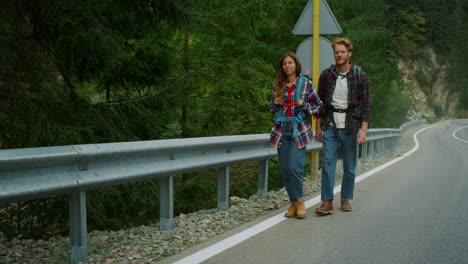 amigos felices caminando por el camino en las montañas la naturaleza. pareja positiva hablando juntos