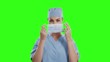 caucasian female doctor wearing face mask on green screen background