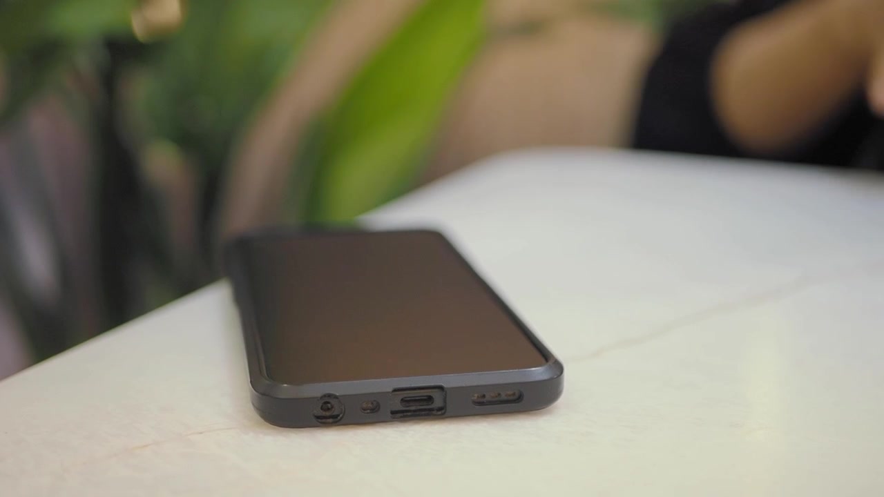 Persona che prende lo smartphone da un tavolo bianco