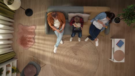 family relaxing at home with digital devices