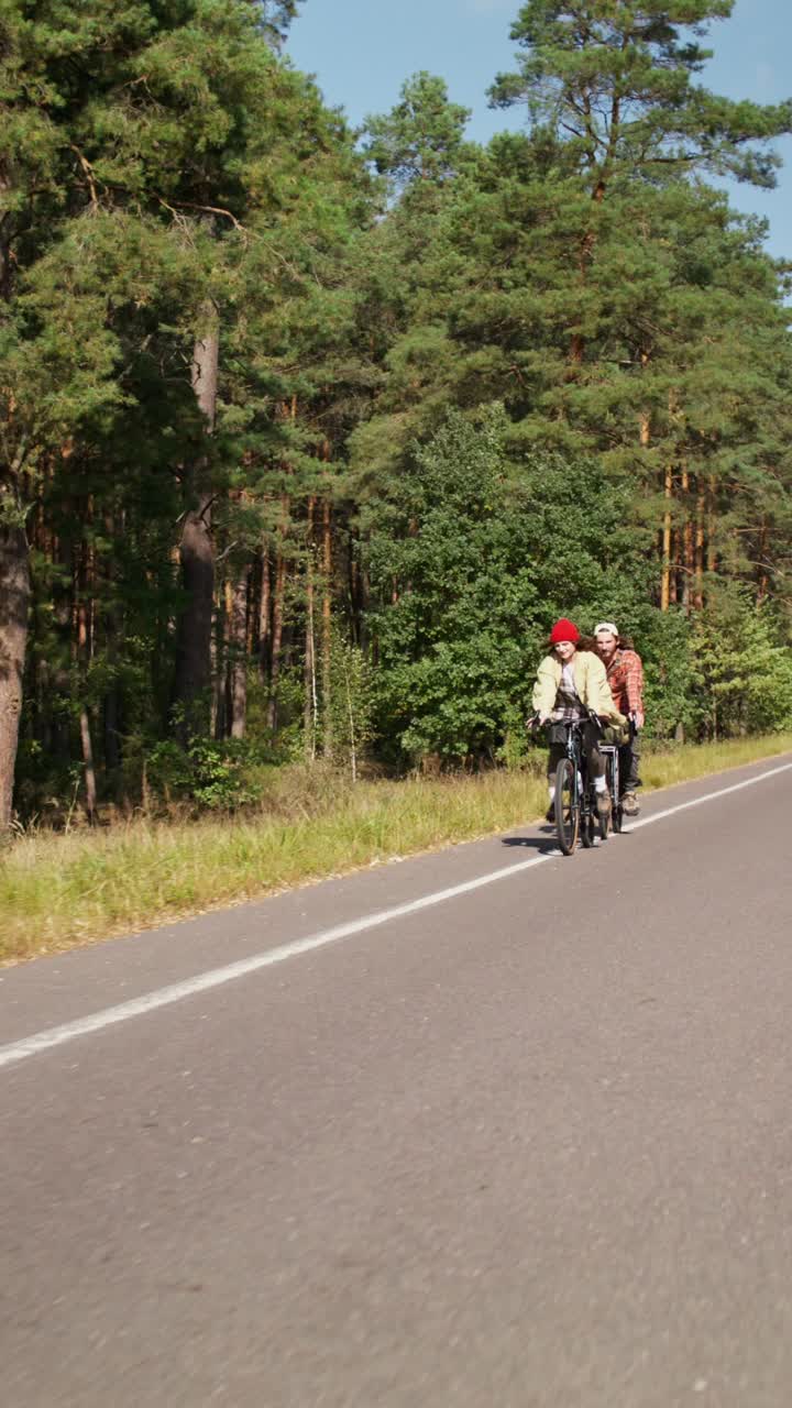Couple cycling through the forest
