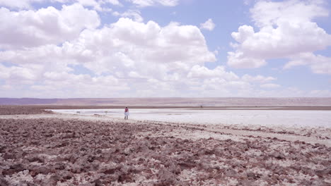 Person-Seen-Walking-Across-Dry-Arid-Desert-Landscape-In-The-Atacama