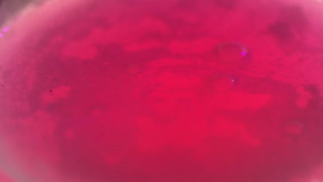 vibrant pink bubbles pop from carbonated japanese bath salts in slow motion