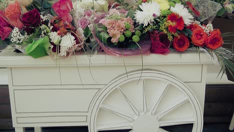 many beautiful flowers on decorative cart