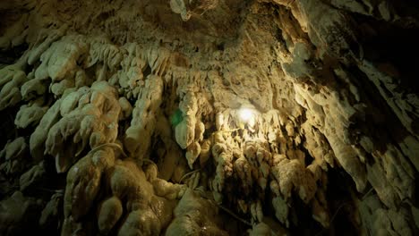 stalactite stalagmites inside cave landscape low angle close up panning right