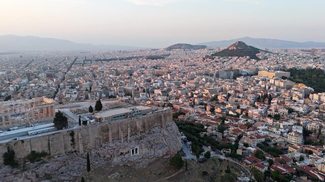 Dinding batu Akropolis Athena dan Parthenon berdiri di atas bukit berbatu saat drone terbang melintas menuju ibu kota Yunani yang ramai