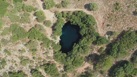 Aerial-ascending-view-Natural-clear-water-lake,-Melissani-cave,-Greece