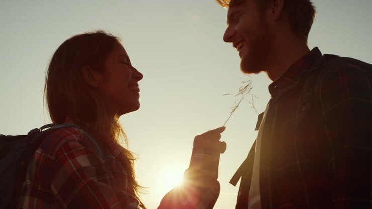 Couple looking at each other at sunset in mountains