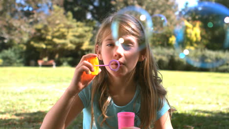 cute young girl blowing into a bubble wand