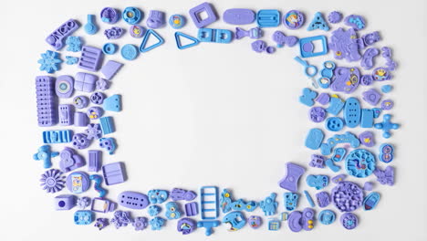 assorted purple and blue toy shapes arranged as a frame on white background