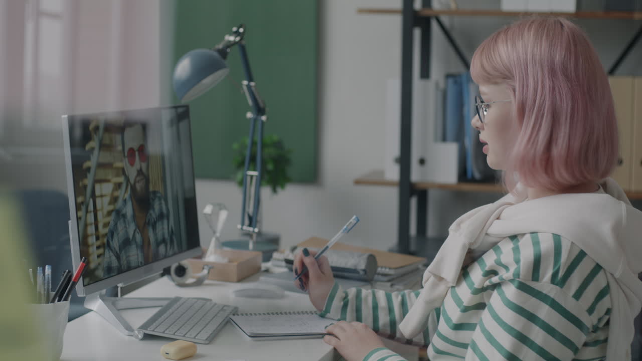 Woman in online meeting taking notes