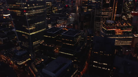 Aerial-view-of-tall-buildings-in-modern-business-office-district.-Working-in-late-evening.-Light-in-office-windows.-London,-UK