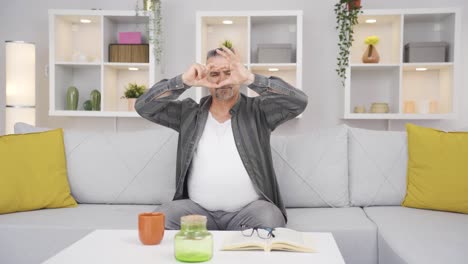 Old-man-making-heart-symbol-for-camera.