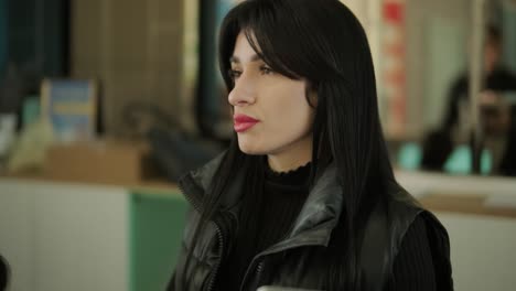 professional female manager in a black formal outfit, walking through the office, interacting with colleagues, holding documents and a laptop, showcasing leadership and professionalism