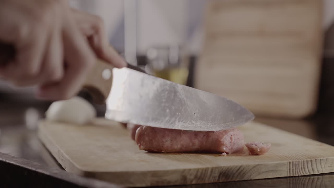Close-up of hands chopping raw meat with a knife on a cutting board